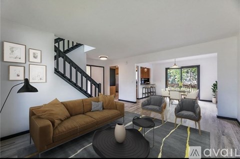 A living room with a brown couch and a black floor lamp.
