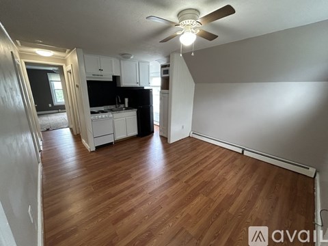 A room with wooden flooring and a ceiling fan.