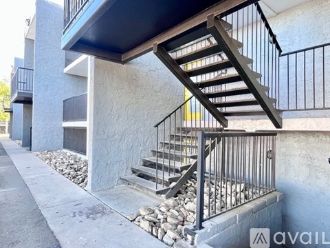 A staircase with a metal railing leads up to a building.