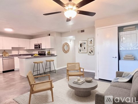 A living room with a grey couch, a wooden chair, and a coffee table.