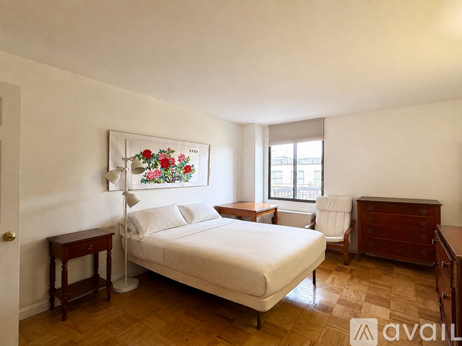 A bedroom with a bed, nightstand, and chair.