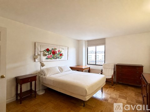 A bedroom with a bed, nightstand, and chair.