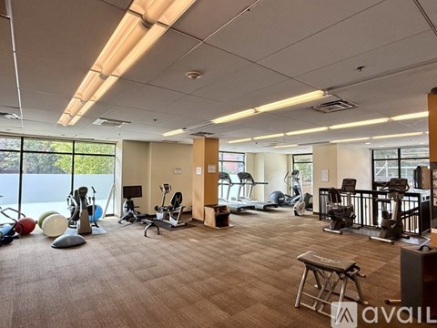 A gym with a variety of equipment including treadmills, weights, and exercise machines.