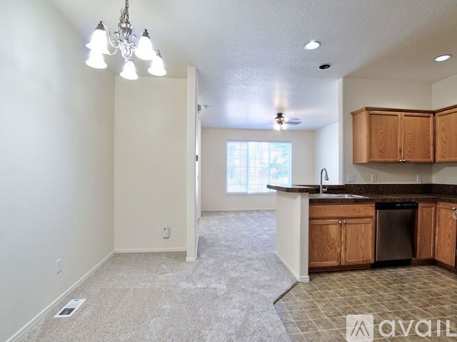 A kitchen with wooden cabinets and a dishwasher is available for rent.