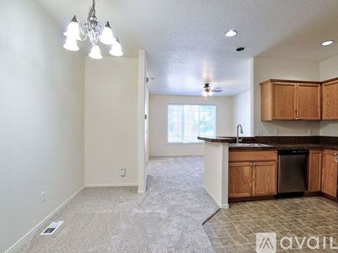 A kitchen with wooden cabinets and a dishwasher is available for rent.