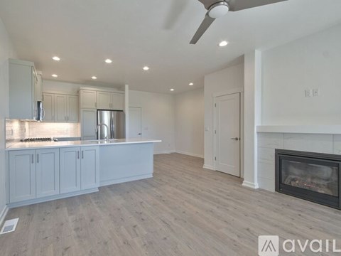 A spacious kitchen with a fireplace and a ceiling fan.