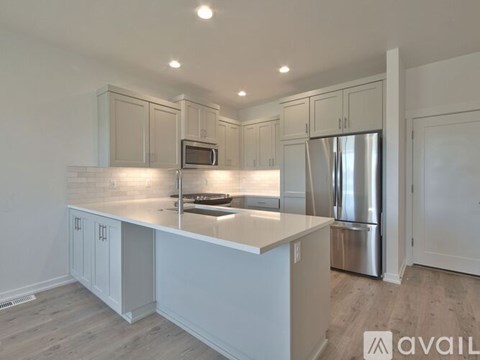A kitchen with white cabinets and a stainless steel refrigerator.