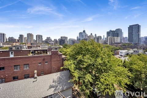 A cityscape with a mix of modern and older buildings, with a clear blue sky above.