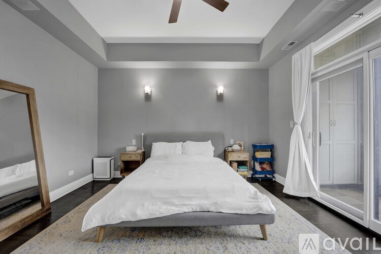 A bedroom with a white bed and a ceiling fan.