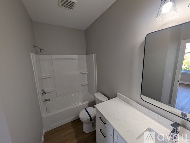 A white bathroom with a toilet, sink, and shower.