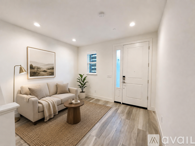 A living room with a couch, a coffee table, and a painting on the wall.