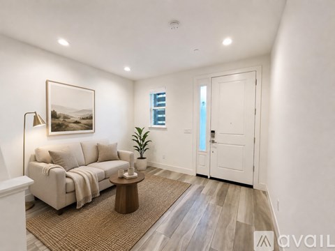 A living room with a couch, a coffee table, and a painting on the wall.