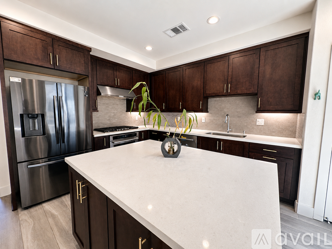 A kitchen with dark brown cabinets and a white countertop.