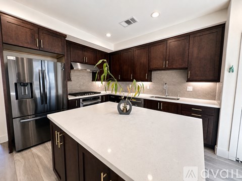 A kitchen with dark brown cabinets and a white countertop.
