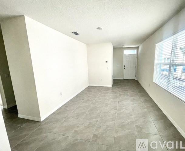 A spacious room with tiled flooring and white walls.