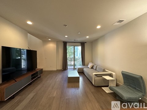 A modern living room with a television, sofa, and coffee table.