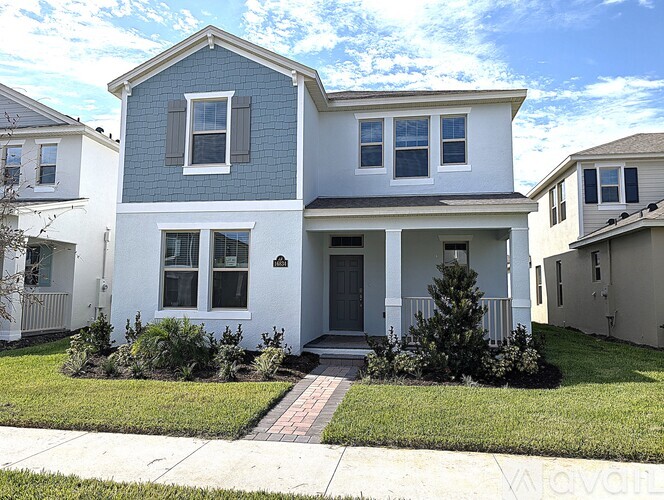 A two-story house with a grey roof and white walls.