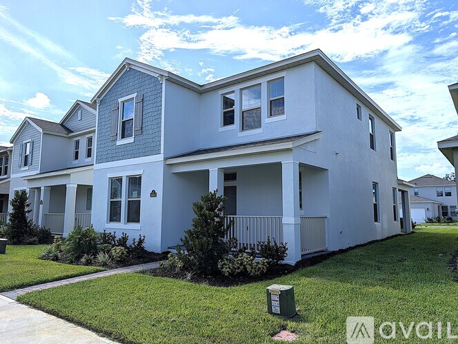 A two-story house with a white and grey exterior is for sale.