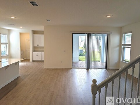 A spacious living room with a staircase leading to the upper floor.