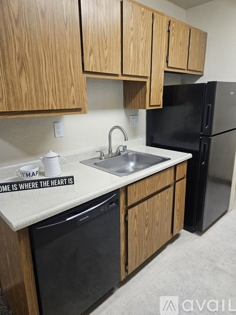 A kitchen with wooden cabinets and black appliances.