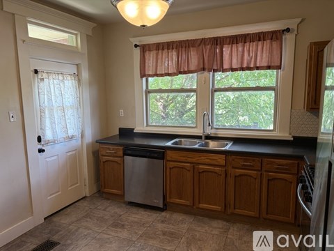 A kitchen with wooden cabinets and a black countertop.