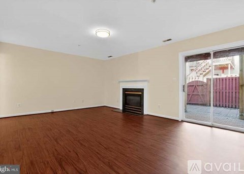 A room with a fireplace and wooden flooring.