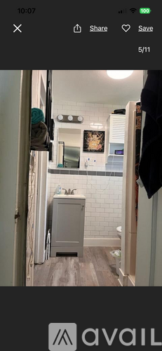 A bathroom with a grey cabinet and a mirror above it.