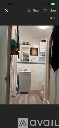 A bathroom with a grey cabinet and a mirror above it.