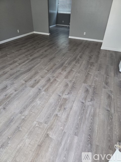 A room with a wooden floor and a white wall.