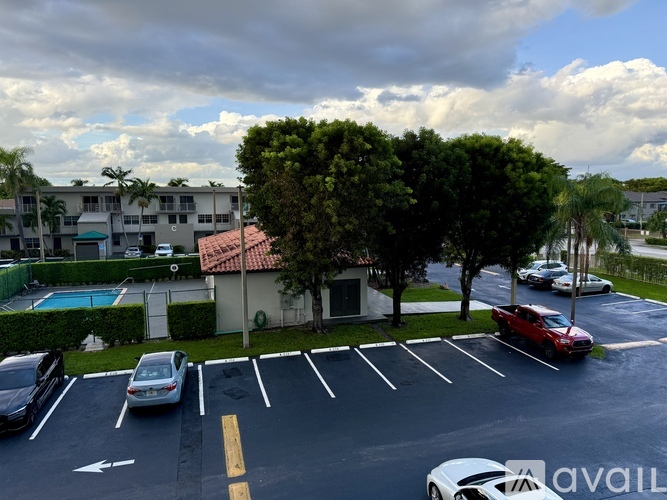 A parking lot with cars and a building in the background.