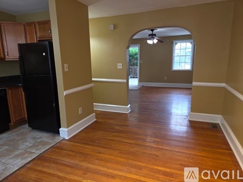 A kitchen with a black refrigerator and wooden cabinets.