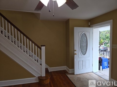 A room with a staircase and a door leading to a balcony.