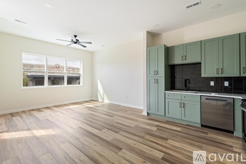 A kitchen with green cabinets and a wooden floor.