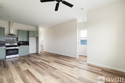 A spacious room with a ceiling fan and wooden flooring.
