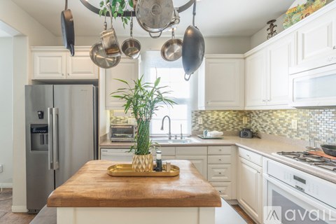 A kitchen with a wooden island and a refrigerator.