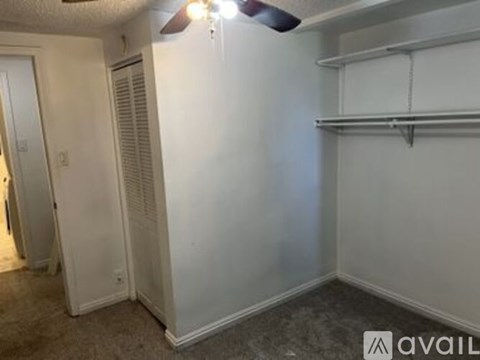 A room with a ceiling fan and a wall-mounted air conditioner unit.