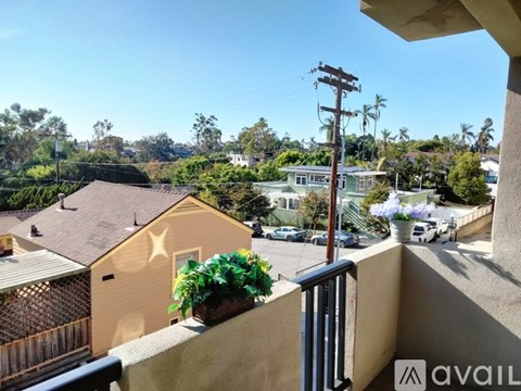 A balcony overlooks a residential area with houses and trees.
