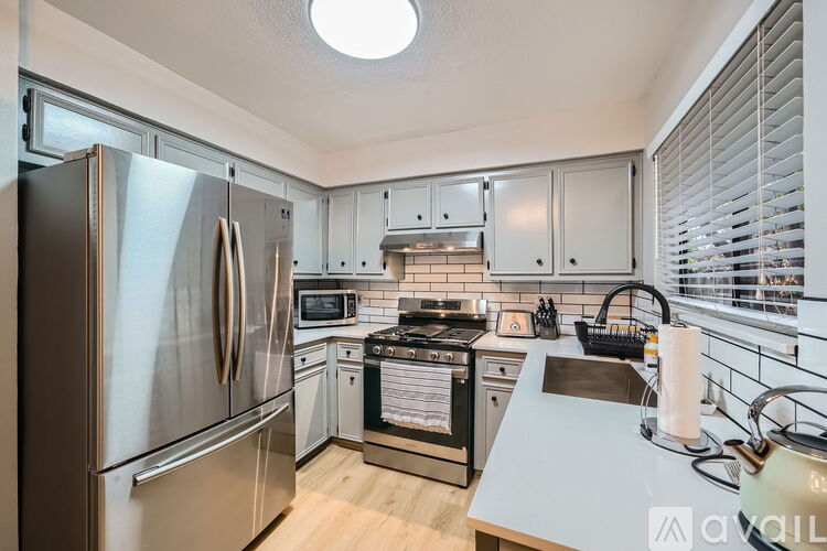 A kitchen with a stainless steel refrigerator and a white countertop.