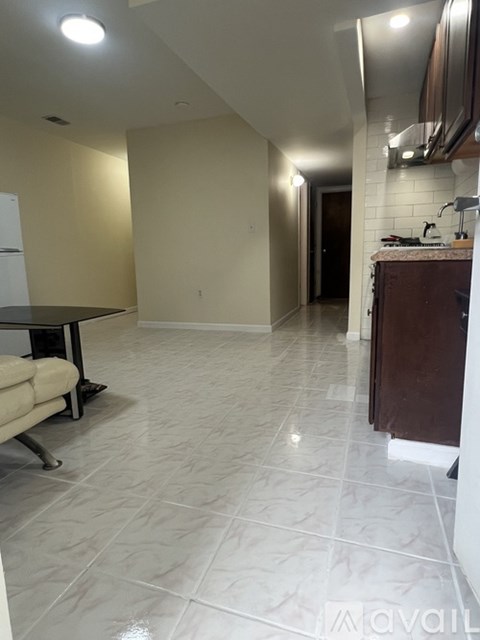 A kitchen with white tiled floors and a dining table with chairs.