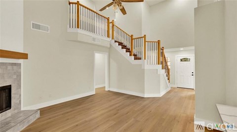 A spacious living room with a staircase leading to the upper level.
