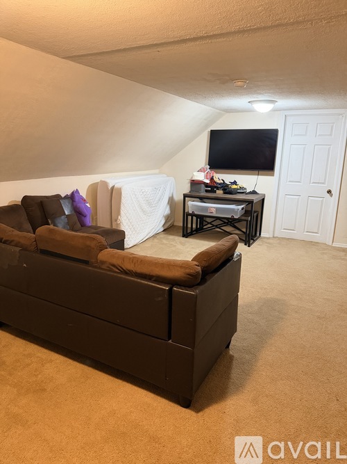 A living room with a brown couch and a white blanket.