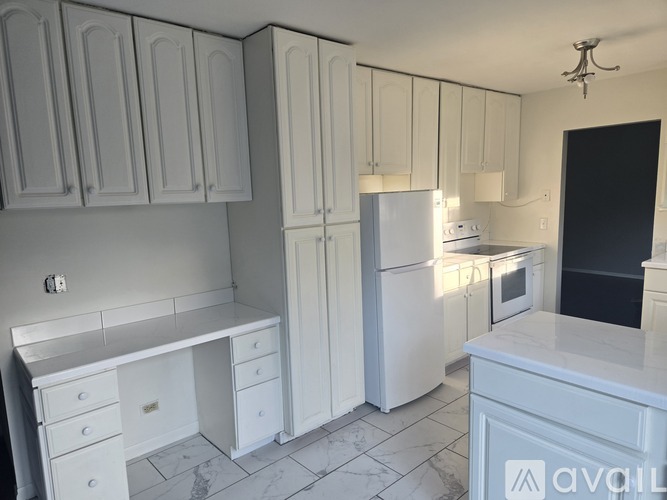 A kitchen with white cabinets and appliances.