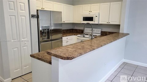 A kitchen with white cabinets and a granite countertop.