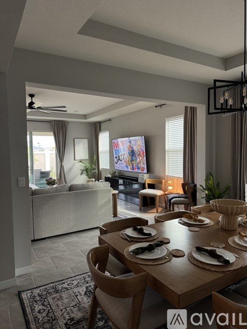 A modern dining room with a wooden table set for a meal.