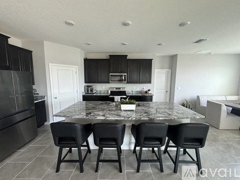A kitchen with a table and chairs in the foreground.