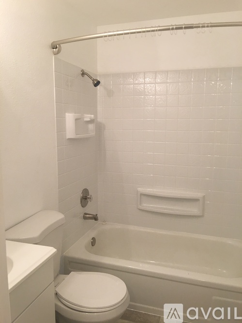 A white toilet sits next to a white sink in a small bathroom.