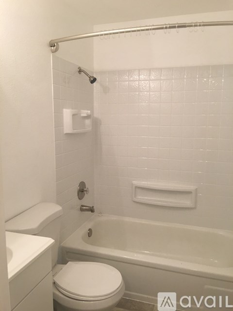 A white toilet sits next to a white sink in a small bathroom.