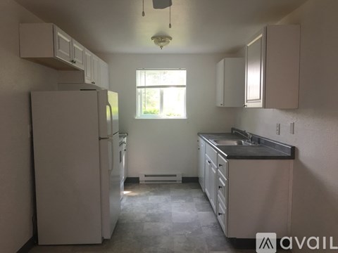 A kitchen with white appliances and cabinets is available for rent.