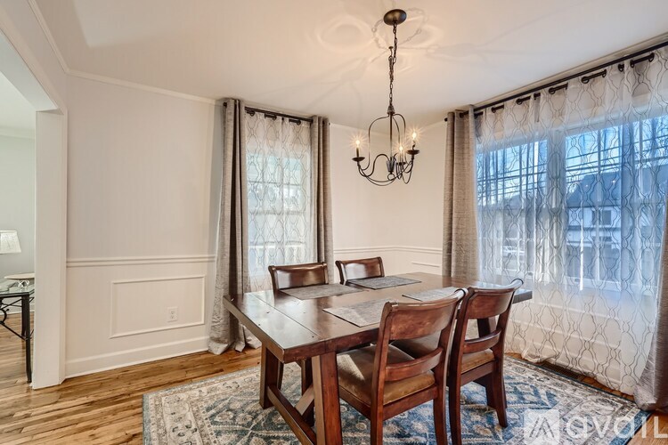 A dining room with a wooden table and chairs.