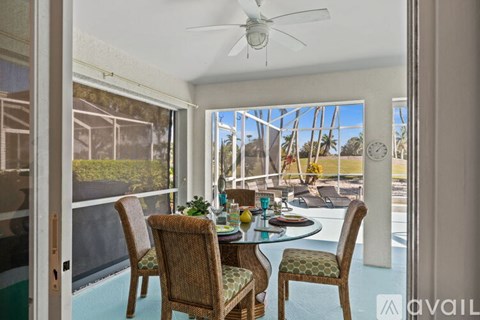 A dining room with a table set for four and a view of the backyard.